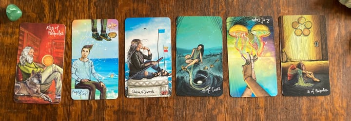 Six tarot cards laid in line: King of Pents, Pg of Cups, Q of Swords, 5 of Cups, 2 of Cups (R), 5 of Pents